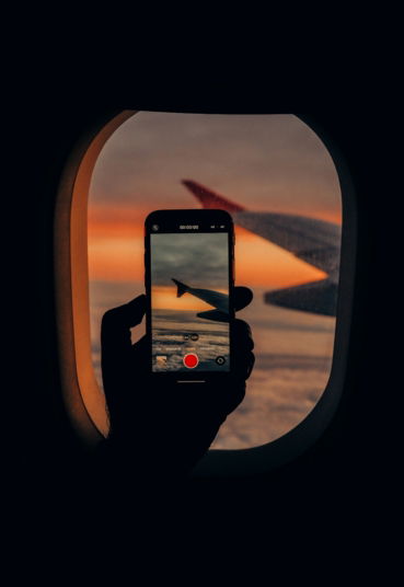 a person taking a picture of an airplane window